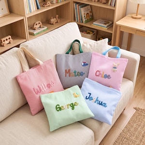Peut inclure: Cinq sacs fourre-tout en tissu de différentes couleurs, notamment rose, gris, vert clair et bleu clair, chacun présentant de fines rayures verticales et un prénom personnalisé brodé en lettres colorées en relief avec des appliques.