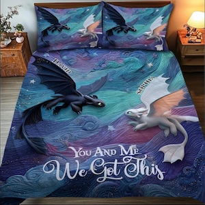 Könnte beinhalten: Ein Bettwäsche-Set mit einem Fantasy-Drachen-Design. Die Bettdecke und die Kissenbezüge zeigen einen schwarzen Drachen und einen weißen Drachen mit den Namen "David" und "Sophia". Der Text "You And Me We Got This" ist ebenfalls sichtbar. Der Hintergrund ist eine wirbelnde Mischung aus Blau, Lila und Türkis.