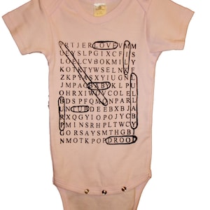 May include: A pink baby onesie with a black word search puzzle printed on the front. The puzzle includes the words "LOVE", "MOM", "DAD", "BABY", and "KIDS".