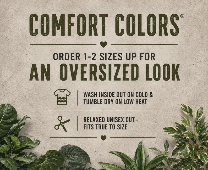 Puede incluir: Imagen con el texto "COMFORT COLORS" e instrucciones para pedir 1-2 tallas m&aacute;s grandes para un look oversize. El texto adicional incluye instrucciones de lavado y secado, y la frase "RELAXED UNISEX CUT - FITS TRUE TO SIZE". El fondo es de un color neutro y texturizado.