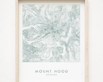 May include: A framed print of a topographic map of Mount Hood, Oregon. The map is in shades of green and white, with the mountain's peak at the center. The text "MOUNT HOOD" and "OREGON" is printed below the map.