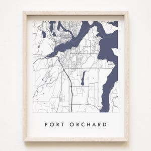 Puede incluir: Una impresión enmarcada del mapa de Port Orchard, con un contorno detallado de calles y agua en azul marino sobre un fondo blanco. El nombre de la ciudad está impreso en una fuente limpia y sans-serif en la parte inferior.