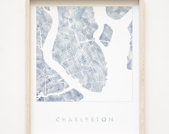 May include: A framed watercolor print of a map of Charleston, South Carolina. The map is in shades of blue and gray, with the city's streets and waterways clearly visible. The word "Charleston" is printed in gray at the bottom of the print.