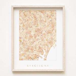 Könnte beinhalten: Gerahmter Druck einer Karte von Barcelona, Spanien, in Beige-, Pfirsich- und Weißtönen. Die detaillierte Stadtkarte zeigt Straßen und Gebäude. Das Wort "BARCELONA" ist in Gold am unteren Rand des Drucks aufgedruckt.