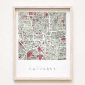 Könnte beinhalten: Gerahmter Aquarelldruck der Karte von Columbus, Ohio, in Grau- und Rottönen. Die Stadtkarte zeigt weiße Straßen und Autobahnen, mit dem Stadtnamen in Grau am unteren Rand. Der Druck befindet sich in einem hellen Holzrahmen.