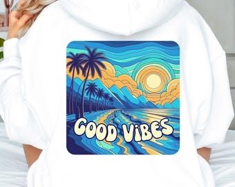 Puede incluir: Sudadera con capucha blanca con un gráfico colorido en la espalda. El gráfico presenta una escena de playa con palmeras, montañas y una puesta de sol. Las palabras "GOOD VIBES" están escritas en una fuente ondulada.