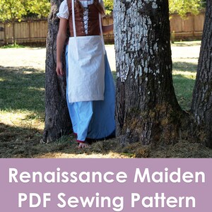 Op de afbeelding: Een jong persoon draagt een witte kap, een bruin korset, een witte schort en een blauwe rok en staat tussen twee bomen. De tekst "Renaissance Maiden PDF Sewing Pattern Muse of the Morning.com" wordt onder de afbeelding weergegeven.