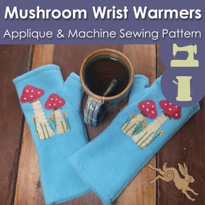 May include: A pair of blue fleece wrist warmers with mushroom appliques. The appliques are made of felt and are stitched on with embroidery floss. The wrist warmers are lying on a wooden surface.