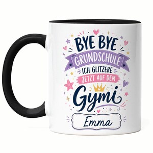 Könnte beinhalten: Ein weißer Keramikbecher mit schwarzem Henkel und schwarzem Innenrand. Auf der Vorderseite steht der bunte Text BYE BYE GRUNDSCHULE ICH GLITZERE JETZT AUF DEM Gymi sowie der Name Emma, verziert mit rosa und lila Herzen, Sternen und einer kleinen goldenen Krone.