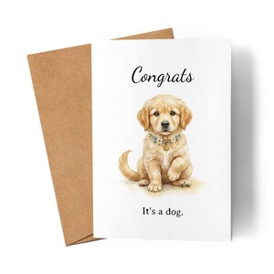 Könnte beinhalten: Eine Grußkarte mit einer Aquarellillustration eines Golden Retriever-Welpen mit einem Blumenhalsband. Die Karte trägt die Aufschrift "Congrats" und "It's a dog.". Die Karte wird von einem braunen Umschlag begleitet.