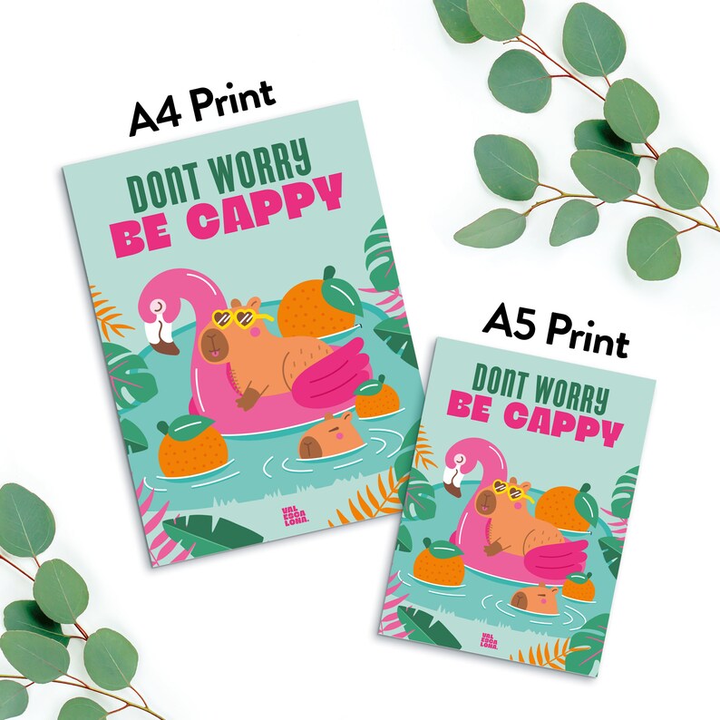 Puede incluir: Una impresi&oacute;n azul claro y verde con un capibara con gafas de sol flotando en un flotador de piscina rosa en forma de flamenco. El texto "Don't Worry Be Cappy" est&aacute; escrito en letras negras. La impresi&oacute;n est&aacute; disponible en tama&ntilde;os A4 y A5.