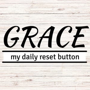Könnte beinhalten: Ein Holzschild mit dem Wort "GRACE" in großen, fetten, schwarzen Buchstaben. Darunter steht der Satz "my daily reset button" in kleinerer Schrift. Der Hintergrund hat ein helles Holzmaserungsmuster.