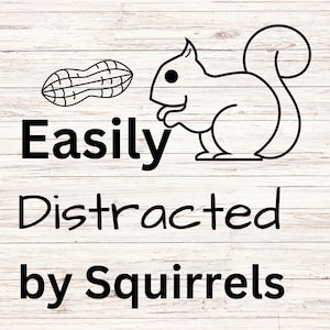 May include: Black and white illustration of a squirrel with a peanut on a white wood background. The text "Easily Distracted by Squirrels" is below the squirrel.