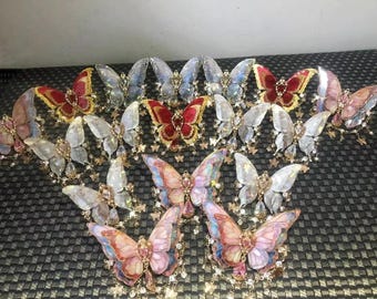 Puede incluir: Un conjunto de 12 pinzas para el pelo con forma de mariposa con alas iridiscentes y detalles dorados. Las pinzas están disponibles en una variedad de colores, incluyendo rojo, rosa y blanco.