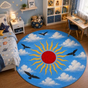 Peut inclure: Tapis rond bleu avec un motif de soleil et d'oiseaux. Le tapis présente un grand soleil rouge au centre avec des rayons jaunes, des nuages blancs et des oiseaux noirs. Idéal pour une chambre d'enfant, environ 150 cm de diamètre.