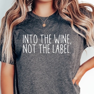 May include: A dark gray t-shirt with the text "Into the wine, not the label." printed in white.