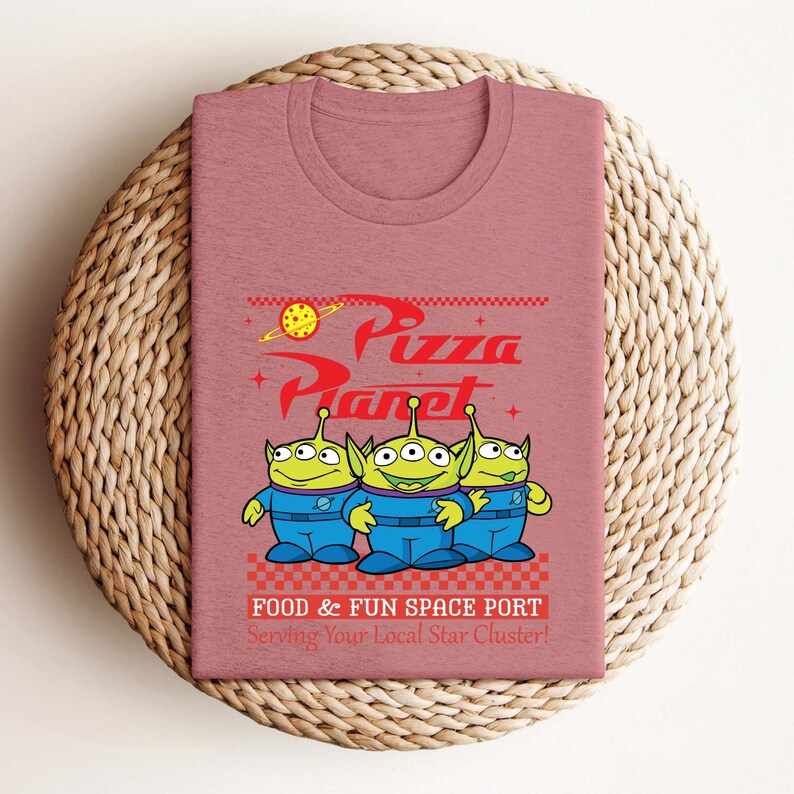 a pink t - shirt with a cartoon character on it