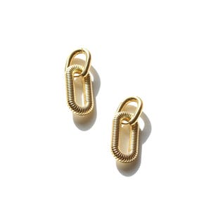 May include: A pair of gold-colored earrings. Each earring features a linked design with a rounded top and a coiled, oval-shaped bottom. The earrings are displayed on a white background, with shadows adding depth.