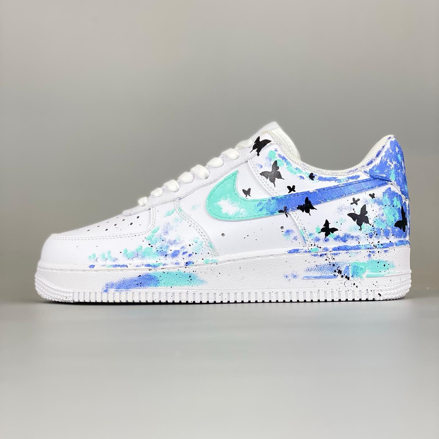 white nike shoes with blue butterflies