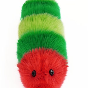 May include: A plush toy caterpillar with a red head and green and lime green segments. The caterpillar has two black eyes.