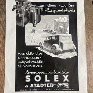 May include: Vintage black and white advert for a Solex carburettor. The advert features an illustration of a car driving in snowy conditions, with text in French. The carburettor is shown in detail.
