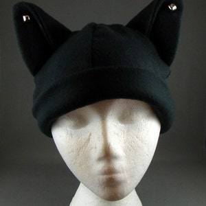 May include: Black fleece cat ear beanie with silver studs on the ears.