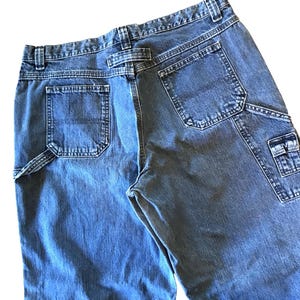 May include: A pair of blue denim carpenter jeans with multiple pockets. The jeans have a light wash and are made of a durable fabric.