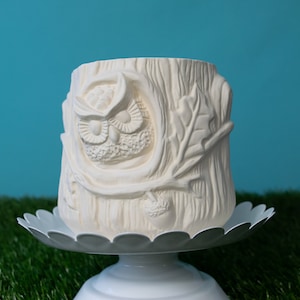 May include: White ceramic owl planter shaped like a tree stump with an acorn and leaves. The owl's eyes are carved into the planter.