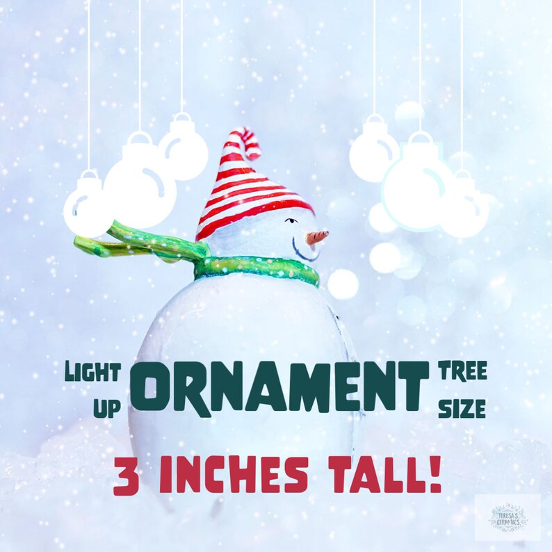 May include: A white snowman ornament with a red and white striped hat and a green scarf. The ornament is 3 inches tall and is a light up Christmas tree ornament.