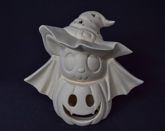 May include: White ceramic Halloween decoration of a bat with a witch hat and a pumpkin face. The bat has large eyes and a small nose. The pumpkin has a carved jack-o'-lantern face.