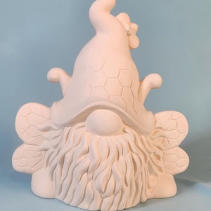 May include: A ceramic gnome figurine with bee-themed details. The gnome wears a tall hat with a honeycomb pattern and small flower. It has large, textured wings and a long, flowing beard. The figurine is unpainted and ready for customization.