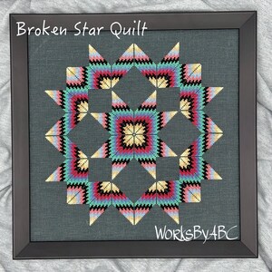 May include: A framed cross-stitch design of a "Broken Star Quilt" with a colorful geometric pattern in shades of pink, blue, green, black, and yellow. The text "WorksByABC" is in the bottom right corner of the image.