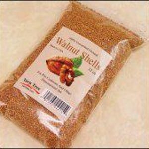 May include: A bag of brown walnut shells. The bag is labeled "Walnut Shells 1.25 lbs.  100% Natural Crushed Walnut Shells.  Dust Free."