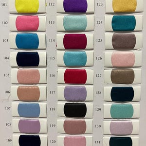 May include: A color chart featuring 33 fabric swatches in various colors, each labeled with a number. The swatches are arranged in rows and columns, showcasing a range of hues from vibrant pinks and blues to neutral tones like beige and gray.