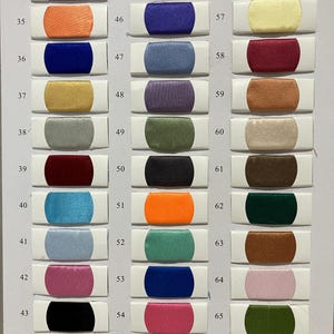 May include: A color chart featuring 33 fabric swatches in various colors, including gray, orange, blue, gold, and burgundy. Each swatch is rectangular with rounded ends and is labeled with a number from 34 to 66.