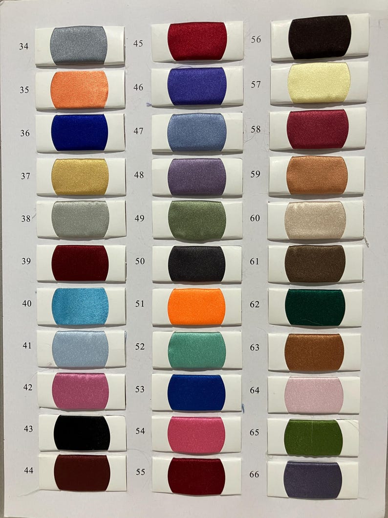 May include: A color chart featuring 33 fabric swatches in various colors, including gray, orange, blue, gold, and burgundy. Each swatch is rectangular with rounded ends and is labeled with a number from 34 to 66.