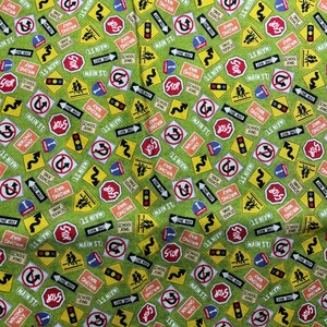 ジョアン ファブリック & クラフト ストアの Debbie Mumm による緑の背景の交通標識生地 - 高速道路の道路標識