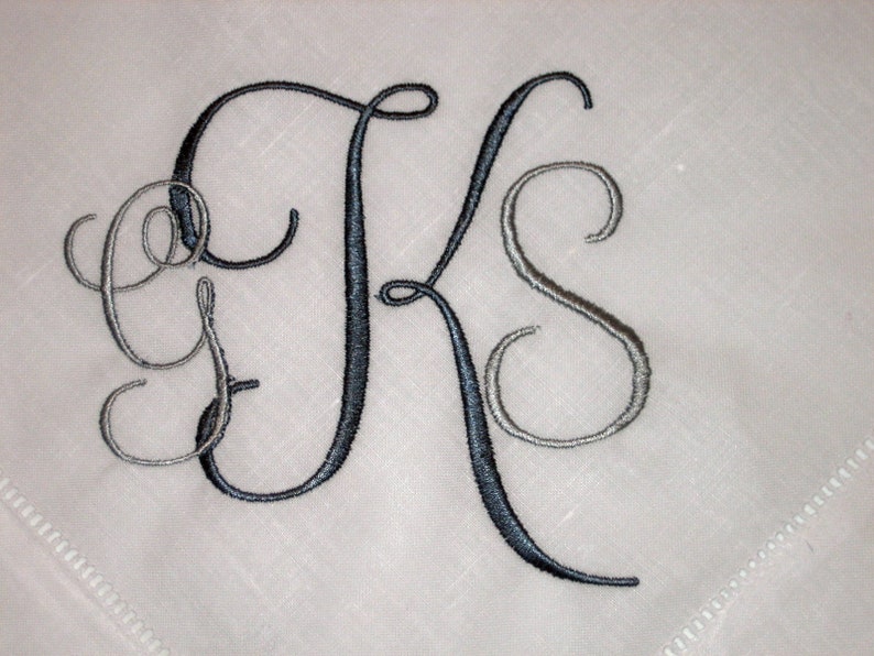 May include: A monogrammed handkerchief with the letters "GKS" embroidered in black and silver thread.