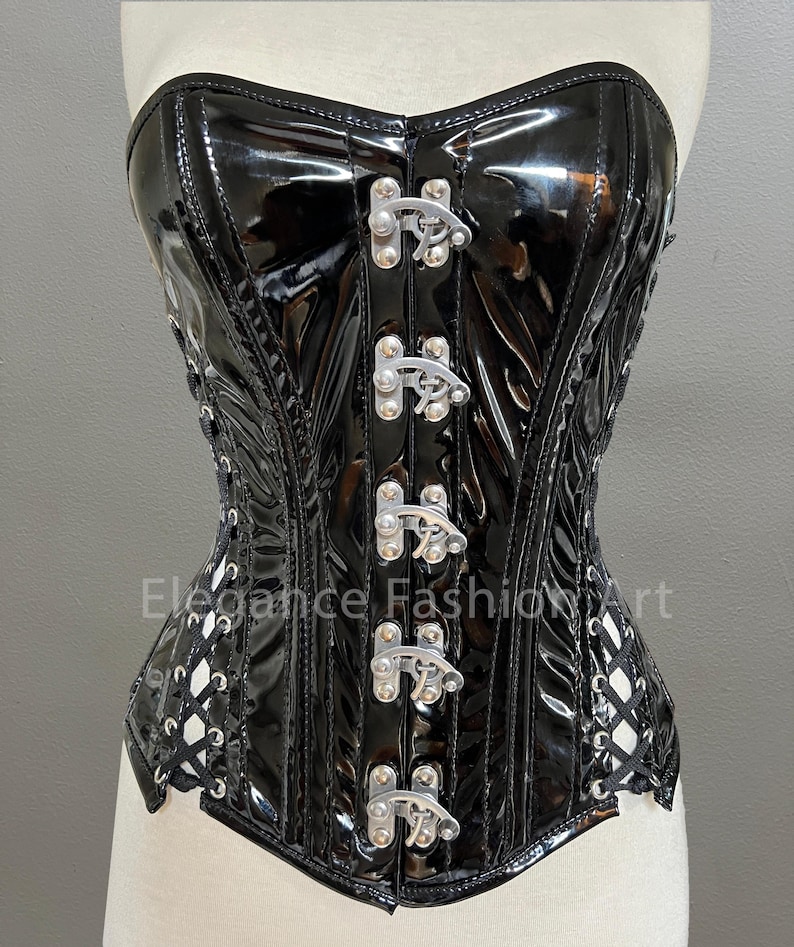 Pu&ograve; includere: Corsetto in pelle verniciata nera con fibbie in metallo argentato e lacci sul retro. Il corsetto ha una struttura a stecche e una finitura liscia e lucida.