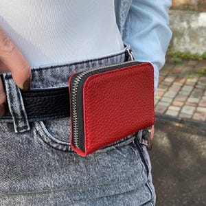 May include: A set of three ceramic mugs with a speckled, cream-colored glaze. Each mug features a different hand-painted floral design in shades of blue, green, and yellow. The mugs have a simple, rounded shape and a comfortable handle.