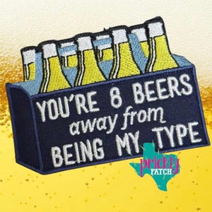 May include: Embroidered patch featuring a navy blue beer carrier with six beer bottles. The text reads "YOU'RE 8 BEERS away from BEING MY TYPE". The patch has a yellow, blue, and white color scheme, with a Texas-shaped logo.