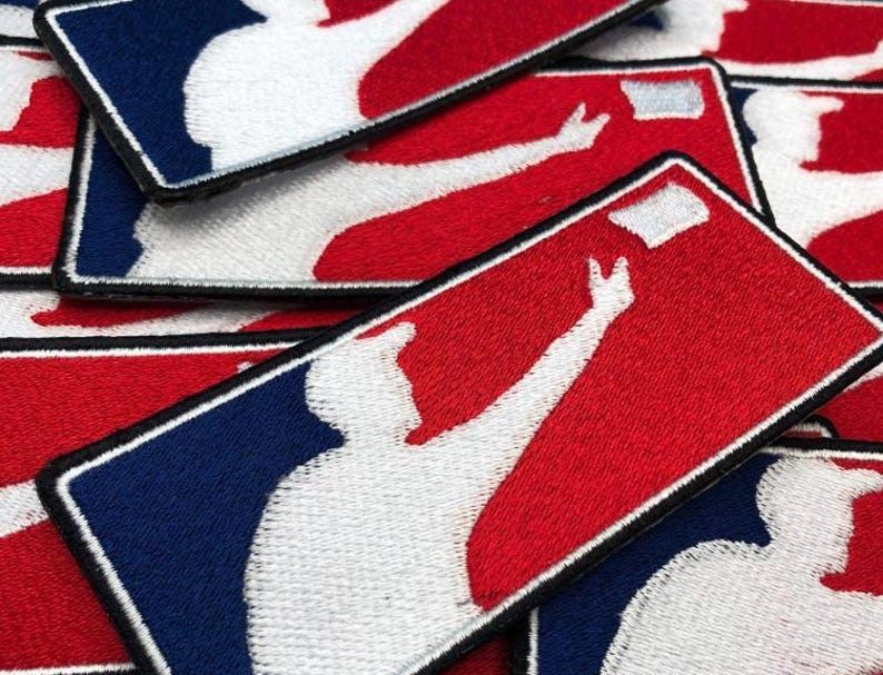 May include: A collection of rectangular embroidered patches featuring a white silhouette of a baseball player in a batting stance against a red and blue background. Each patch has a black stitched border and depicts a player reaching for a ball.
