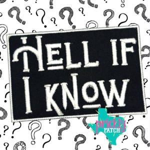 May include: A black rectangular patch with white embroidered text that reads "HELL IF I KNOW". The patch is surrounded by a white border and set against a background of black question marks on a white surface. The patch has a logo in the bottom right corner.