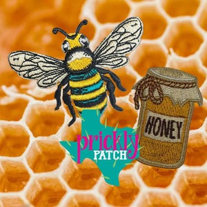 May include: Embroidered patch featuring a detailed bee with yellow, black, and blue stripes, wings spread. A jar of honey with the word "HONEY" is next to the bee. The background is a honeycomb pattern, with the text "prickly patch" in a teal Texas shape.