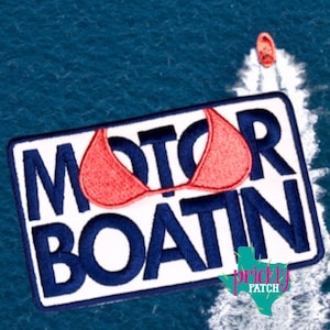 May include: Embroidered patch with the words "MOTOR BOATIN" in navy blue, a red bikini top, and a small Texas-shaped logo. A small orange boat is visible in the background on a blue water surface.