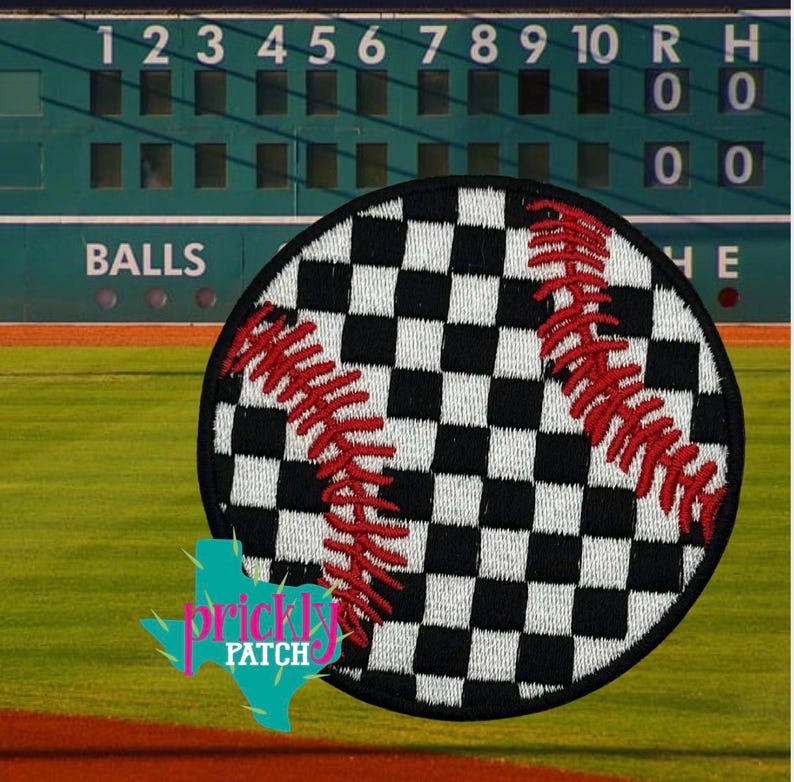 以下が含まれることがあります： 黒と白の市松模様と赤いステッチが施された丸い野球パッチ。パッチは、緑色のスコアボードと「BALLS」という単語が見える野球場の背景に設定されています。