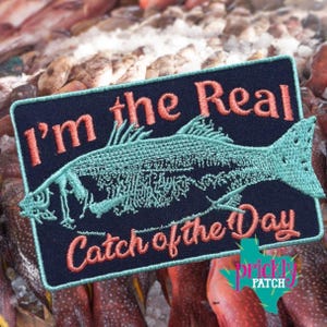 May include: A white ceramic mug with a black handle and the text "But First, Coffee" in a black, handwritten-style font. The mug is on a white surface.