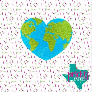 May include: Embroidered patch featuring a blue heart-shaped Earth with green continents. The patch is on a white background with a pattern of pink and green dashes. The lower right corner has a teal Texas-shaped logo with the text "prickly patch".