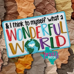 May include: Embroidered patch with the text "& I think to myself what a WONDERFUL WORLD" in colorful letters. The patch features a blue border and a globe graphic. The background is a collage of paper silhouettes.