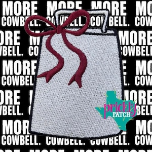 May include: A silver-colored embroidered patch shaped like a cowbell with a dark red ribbon tied in a bow at the top. The patch features a black border and is set against a black background with the repeating white text MORE COWBELL.